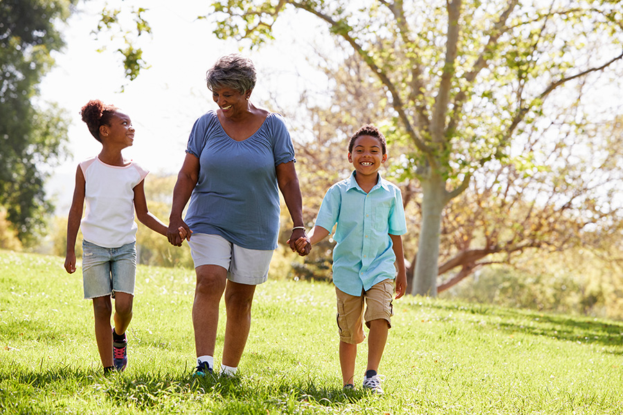 grandmother walking with two grandchildren