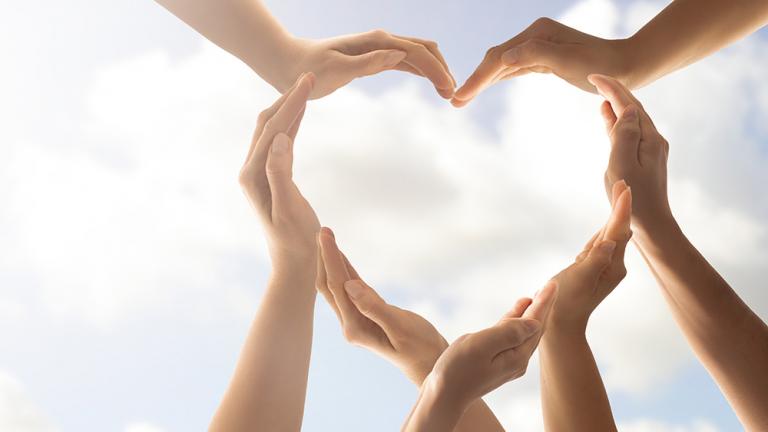 a series of cupped hands form the outline of a heart