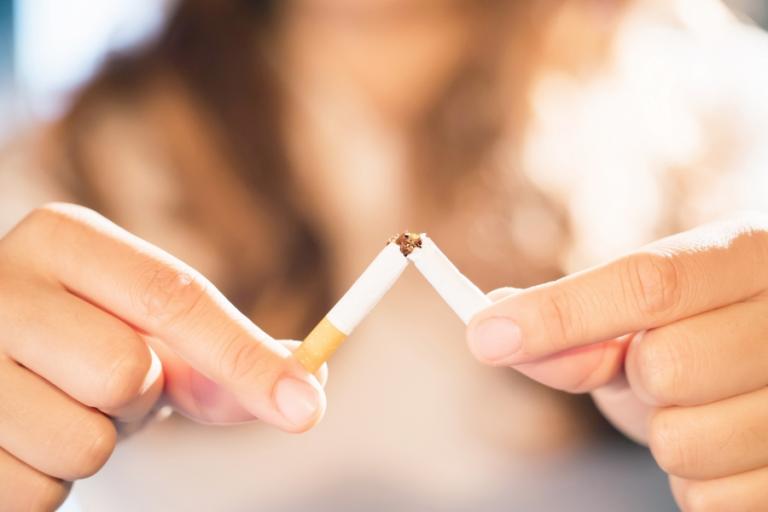 Woman breaking a cigarette in half