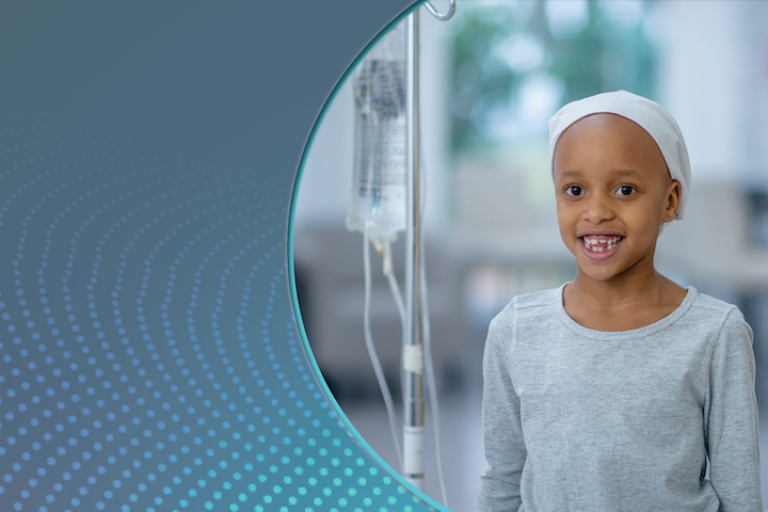 child wearing hat stands next to IV pole with bag of fluids