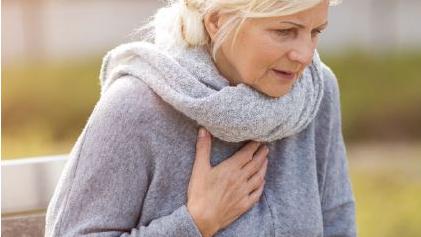 woman holding her chest in discomfort 